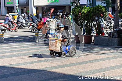 Taipei-Taiwan - DECEMBER 16TH, 2019. Disabled woman on electric wheelchair is selling tissue paper at shopping street in Taiwan Editorial Stock Photo