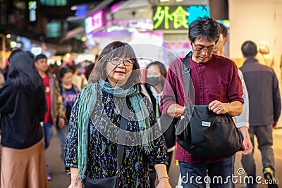 TAIPEI, TAIWAN - JANUARY 05: Unnamed elderly woman happily walks in the Shilin night market in Taipei on January 05, 2020 Editorial Stock Photo