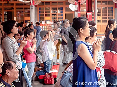 Taipei, Taiwan - May 13, 2019: People Asian with Buddhist incense sticks praying in Longshan Temple. Religious ritual, ceremony. Editorial Stock Photo