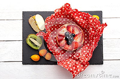 Take away cake inside homemade beeswax wraps. Wrapping food in handmade beeswax wrap cloth indoors, alternative for plastic. Stock Photo