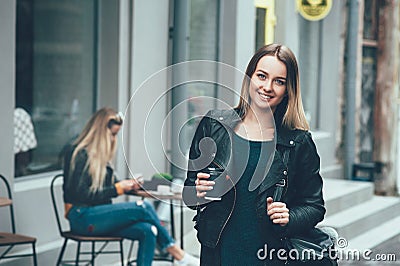 Take away coffee. Beautiful young urban woman wearing in stylish clothes holding coffee cup Stock Photo