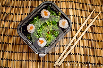 Take away sushi dish with algae and chopsticks Stock Photo