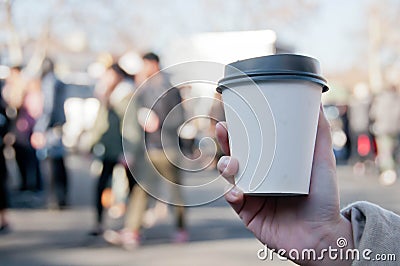 Take away white paper hot coffee cup with right hand holding in Sunday flea market Stock Photo
