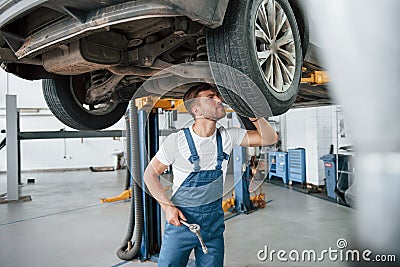 Take closer look. Employee in the blue colored uniform works in the automobile salon Stock Photo