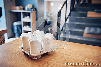 Take coffee to work for the entire office. High angle shot of a cardboard take out tray with four coffee cups with lids Stock Photo