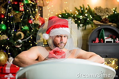 Take delight. Pampering myself. Winter holidays. Christmas concept. Man lying in bathtub relax with gift box. Spa and Stock Photo