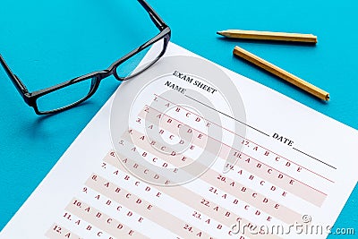 Take the exam. Exam sheet near glasses and pencil on blue background Stock Photo