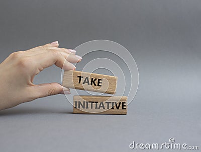 Take initiative symbol. Wooden blocks with words Take initiative. Beautiful grey background. Businessman hand. Business and Take Stock Photo