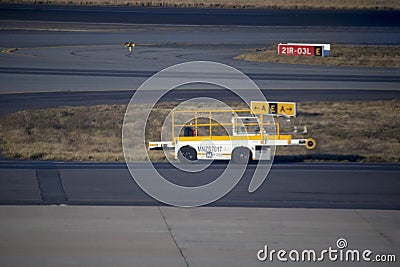 Take-off and landing runways with the vehicle to take the luggage on and off the planes at Johannesburg International Airport in Editorial Stock Photo