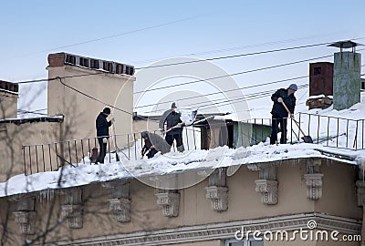 Take off the snow and icicles from the roof. Working cleaning work without insurance. Russia, St. Petersburg Editorial Stock Photo