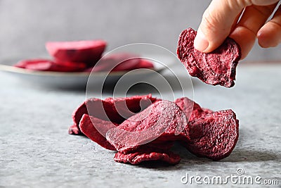 Take a piece vegetable beetroot chips on a gray background. Stock Photo