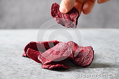 Take a piece vegetable beetroot chips on a gray background. Stock Photo