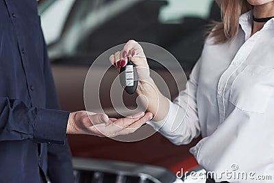 Take your keys and love it. Assistant manager giving advices and help to the customer in automobile salon Stock Photo