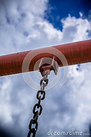 Swing chain detail with blue sky and clouds Stock Photo