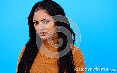 It takes courage to bloom. a beautiful young woman posing against a blue wall. Stock Photo