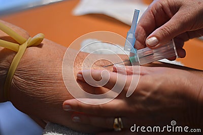 Taking blood from a somewhat old lady Editorial Stock Photo