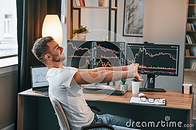 Taking a break. Young stock broker is working in the office by using computer Stock Photo