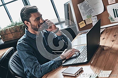 Taking care of business. Top view of handsome young man talking Stock Photo