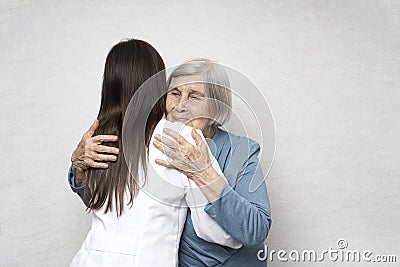 Taking care for the elderly. Young doctor hugs an elderly woman. Stock Photo