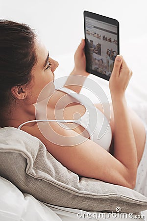 Taking it easy before baby arrives. a pregnant woman using a digital tablet at home. Stock Photo