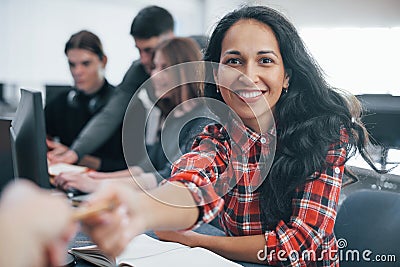 Taking item. Group of young people in casual clothes working in the modern office Stock Photo