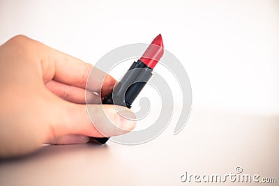 Taking a lipstick: Female hand is taking an elegant, red lipstick Stock Photo