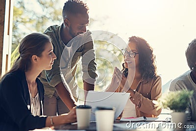 Taking a look at the paperwork over some lunch. a group of creative employees having a breakfast meeting outside. Stock Photo