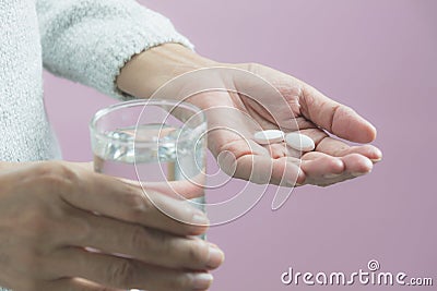 Taking medicine pills. Woman holds in hands the medicine pills a Stock Photo