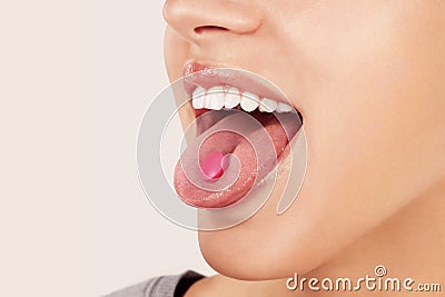 Taking painkiller pill on tongue. Stock Photo