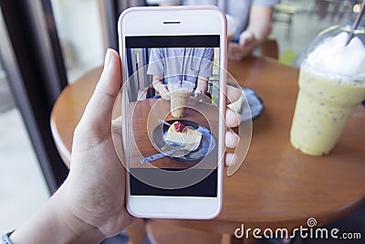 Taking photo of a piece of cake and a cup of coffee Stock Photo