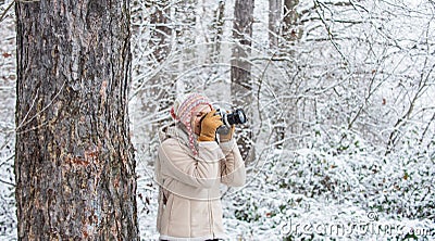 Taking stunning winter photos. Enjoy beauty of snow scenery through photos. Woman photographer with professional camera Stock Photo