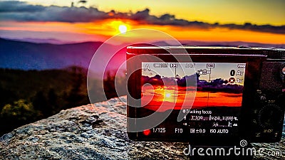 Taking sunset photo with a camera in the mountains Stock Photo