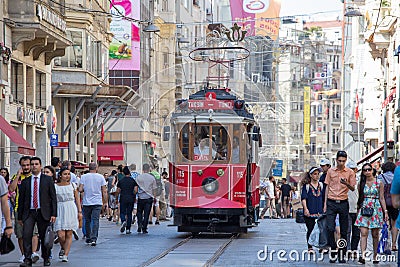 Taksim Tunel Nostalgia Tram trundles along the istiklal street and people at istiklal avenue. Istanbul, Turkey Editorial Stock Photo