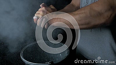 Talc sports. Closeup of a muscular man ready to workout. male powerlifter hand in talc and sports wristbands preparing Stock Photo