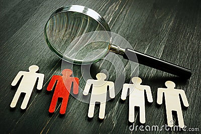 Talent management and development. Wooden figures and magnifying glass. Stock Photo