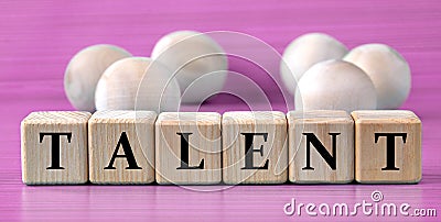 TALENT - word on wooden cubes on pink background with wooden round balls Stock Photo