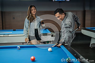 talented male pool player poking the white ball from his back Stock Photo