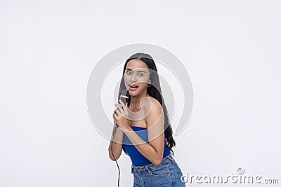A talented young asian vocalist singing on the microphone. A pretty lady doing karaoke and having fun. Isolated on a white Stock Photo