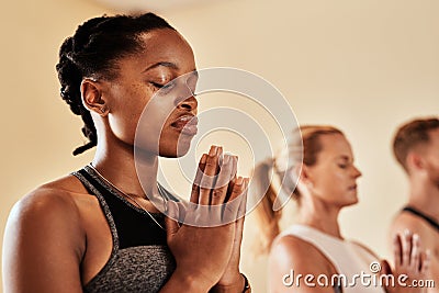 Talk to the universe through meditation. Shot of a group of young men and women meditating in a yoga class. Stock Photo