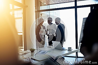 Talking digital boardroom business. a group of business colleagues talking together during a meeting in a boardroom. Stock Photo