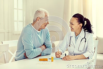 Positive minded elderly man and nurse discussing treatment Stock Photo