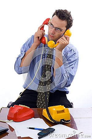 Talking on two telephones Stock Photo