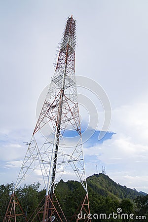 The tall antenna with the mountain and the sky. Stock Photo