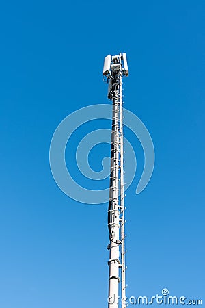 Tall antenna tower for mobile and cellular telephone service with a blue sky background Stock Photo