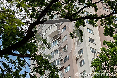 tall apartment building among trees leaves Stock Photo