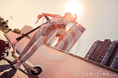 Laughing dark-haired skinny girl transporting on an electronic scooter Stock Photo