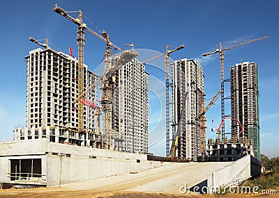 Tall buildings under construction with cranes Stock Photo