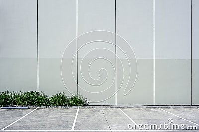 Tall concrete wall next to empty parking. Stock Photo