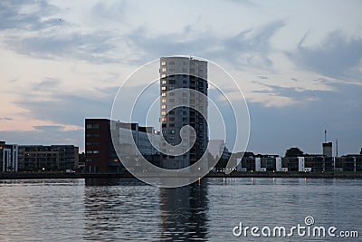 Tall grain silo with its reflection in the river in Aalborg, Denmark Editorial Stock Photo