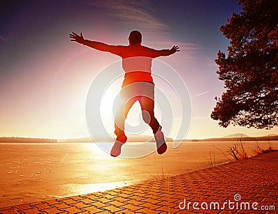 Tall man beach running at sunrise, frozen lake coastline Stock Photo